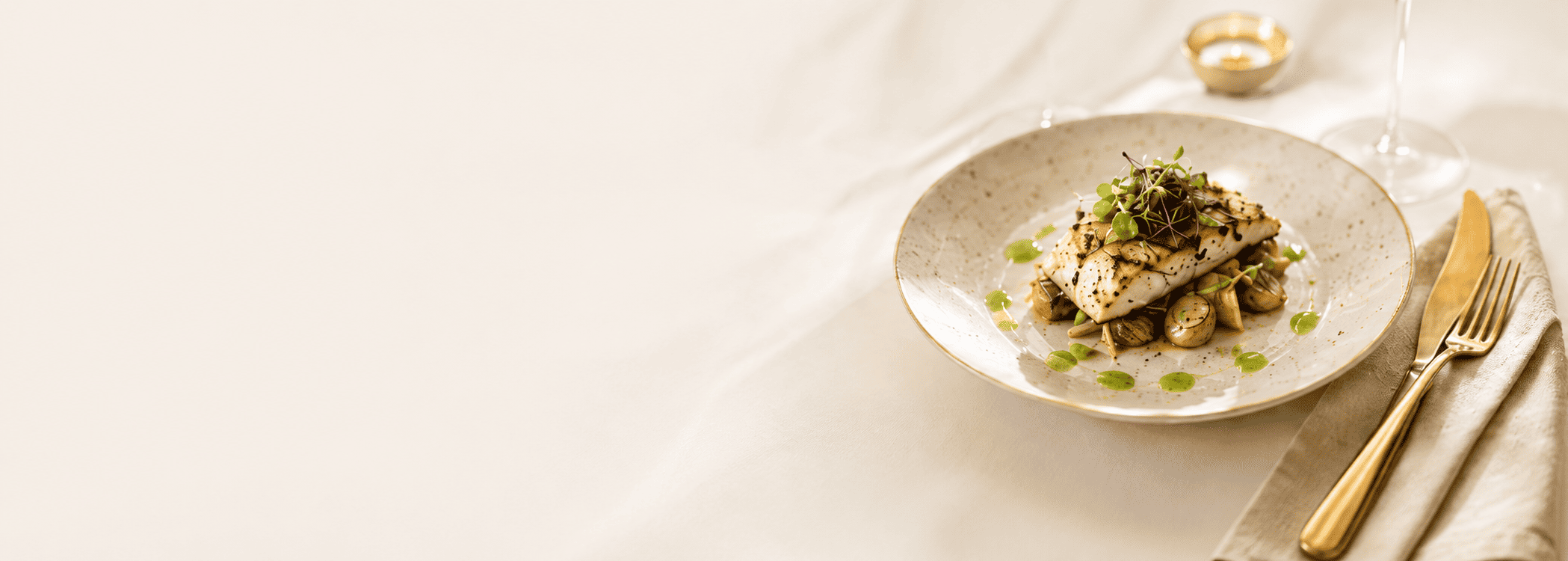 Fine dining dish on a white plate with gold cutlery
